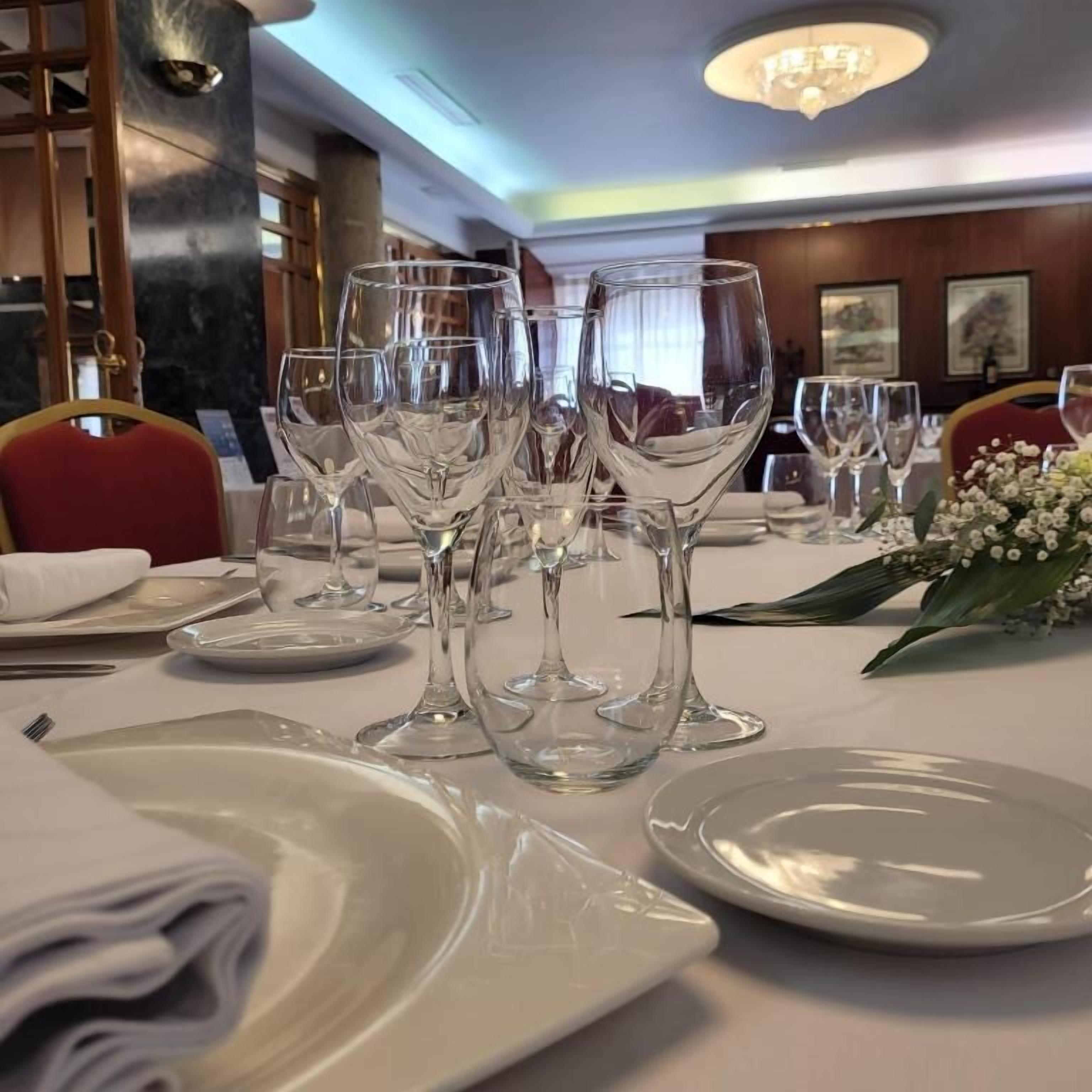 A dining table set with multiple wine glasses and plates, ready for a meal.