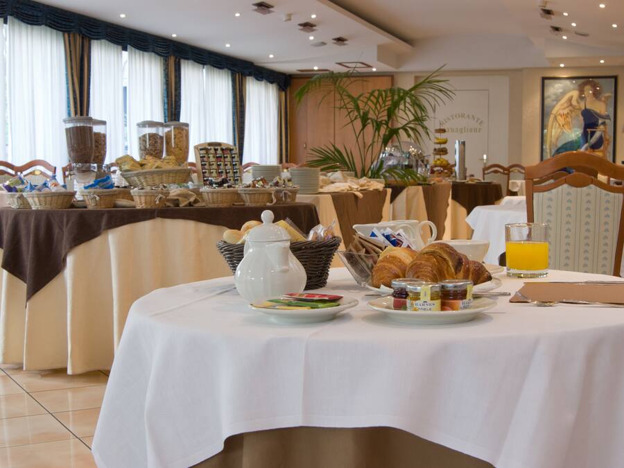 Un buffet per la colazione con diversi cibi e bevande su un tavolo.