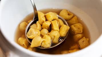 Un tazón de sopa con albóndigas y una cuchara.