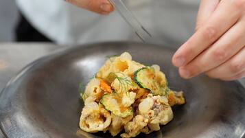 Alguém servindo comida de uma tigela.