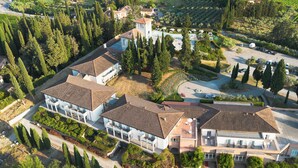 An aerial view of a residential property with multiple buildings, a swimming pool, and a well-maintained garden. - Cappuccina Country Resort (San Gimignano)