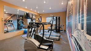 Ein Fitnessstudio mit Laufbändern, Kraftgeräten und Übungsbällen.
