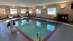A swimming pool with a checkered tile pattern, surrounded by lounge chairs and a lifeguard station.
