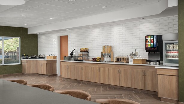 Una cocina moderna con armarios de madera, una isla central y un refrigerador.
