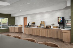 Una cocina moderna con armarios de madera, una isla central y un refrigerador.