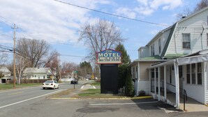 Um motel com uma placa anunciando TV, canais a cabo, internet banda larga e acesso de alta velocidade.
