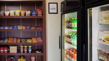 Una estanteria amb aperitius diversos i un expositor refrigerat ple de begudes i aliments congelats.