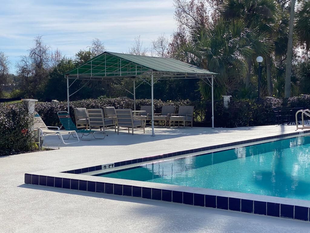 Une piscine dotée d’un espace de repos couvert et de chaises longues.