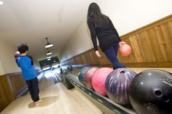 A bowling alley with wooden walls and a bowling lane.