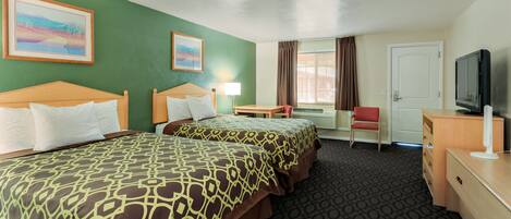 A hotel room with two beds, a desk, a chair, a TV, and a window with curtains.