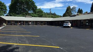 A motel with a large parking lot, multiple rooms, and a building with a flat roof. - Downtown Inn (Eugene)