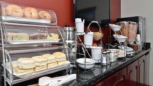 A buffet with various food items including pastries, biscuits, and cereal.