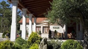 A building with a tiled roof, columns, and a sign reading "MESON." - Hotel Abeiras (O Grove)