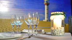 A table set with wine glasses, a candle, and a decorative jar. - Hotel Rull (Deltebre)