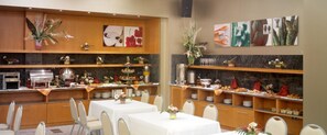 A hotel dining area with multiple tables, chairs, and a buffet setup. - Hotel Rull (Deltebre)