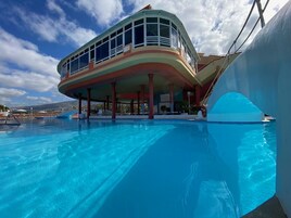 Una piscina al aire libre, sombrillas, tumbonas
