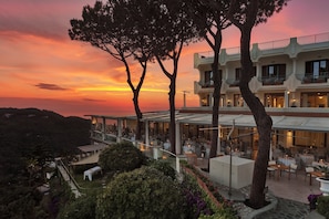 Un hôtel doté d’espaces de restauration en plein air, d’une terrasse couverte et offrant une vue sur le coucher de soleil.
