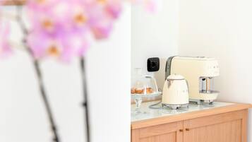 Una encimera de cocina con cafetera, tostadora y un vaso de agua.