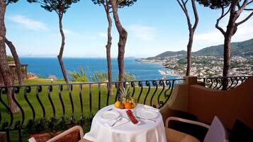 Balcón con mesa lista para dos personas, con vista al mar.