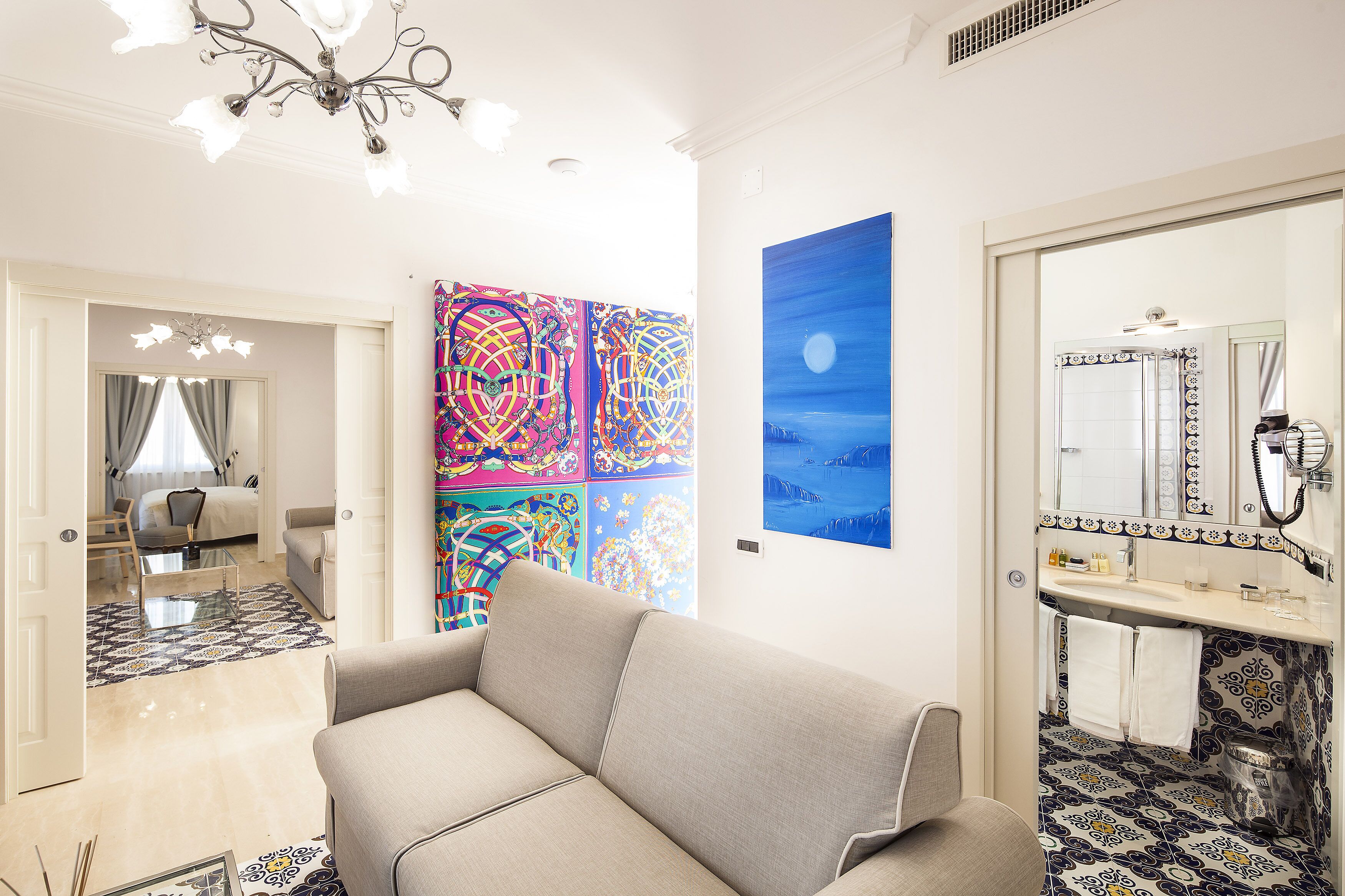 Een moderne woonkamer met een bank, een eettafel en een kleurrijk abstract schilderij aan de muur.