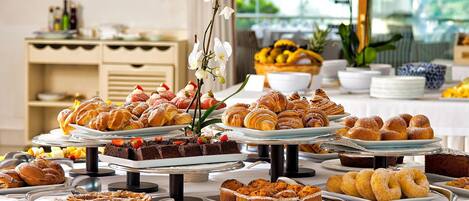 Un bufé con diversas opciones de pasteles, postres y frutas.