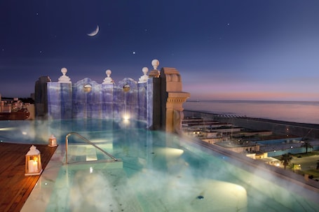 Una piscina al aire libre, sillones reclinables de piscina