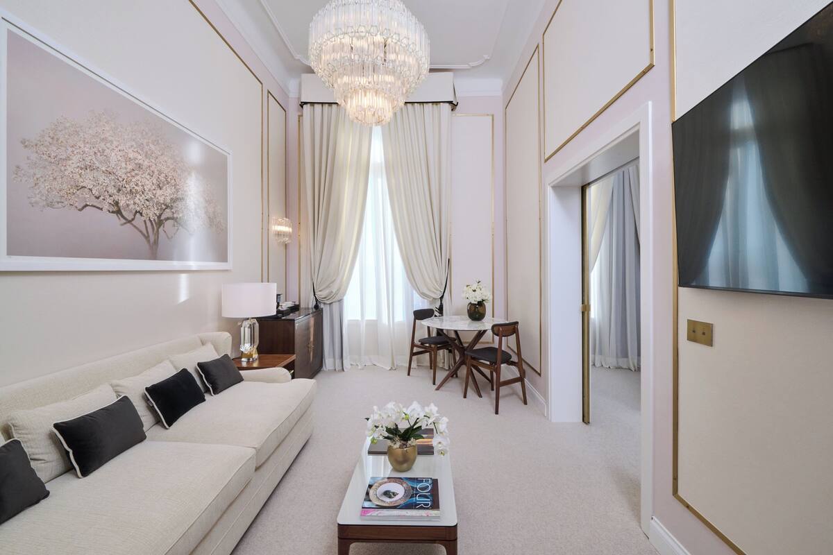 A modern living room with a sofa, coffee table, and dining area.