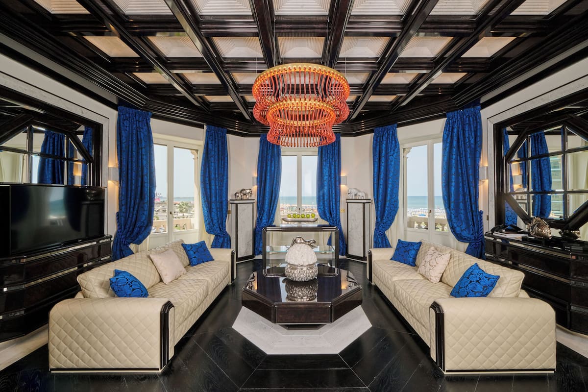 A luxurious living room with a large TV, a piano, and a view of the city.