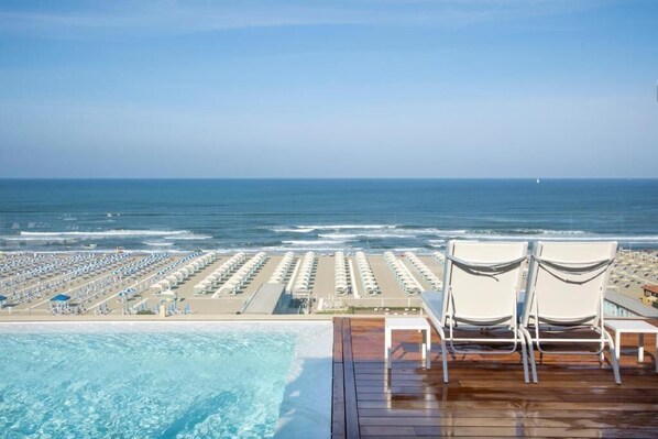 Zona de piscina con vistas a la playa y al océano.