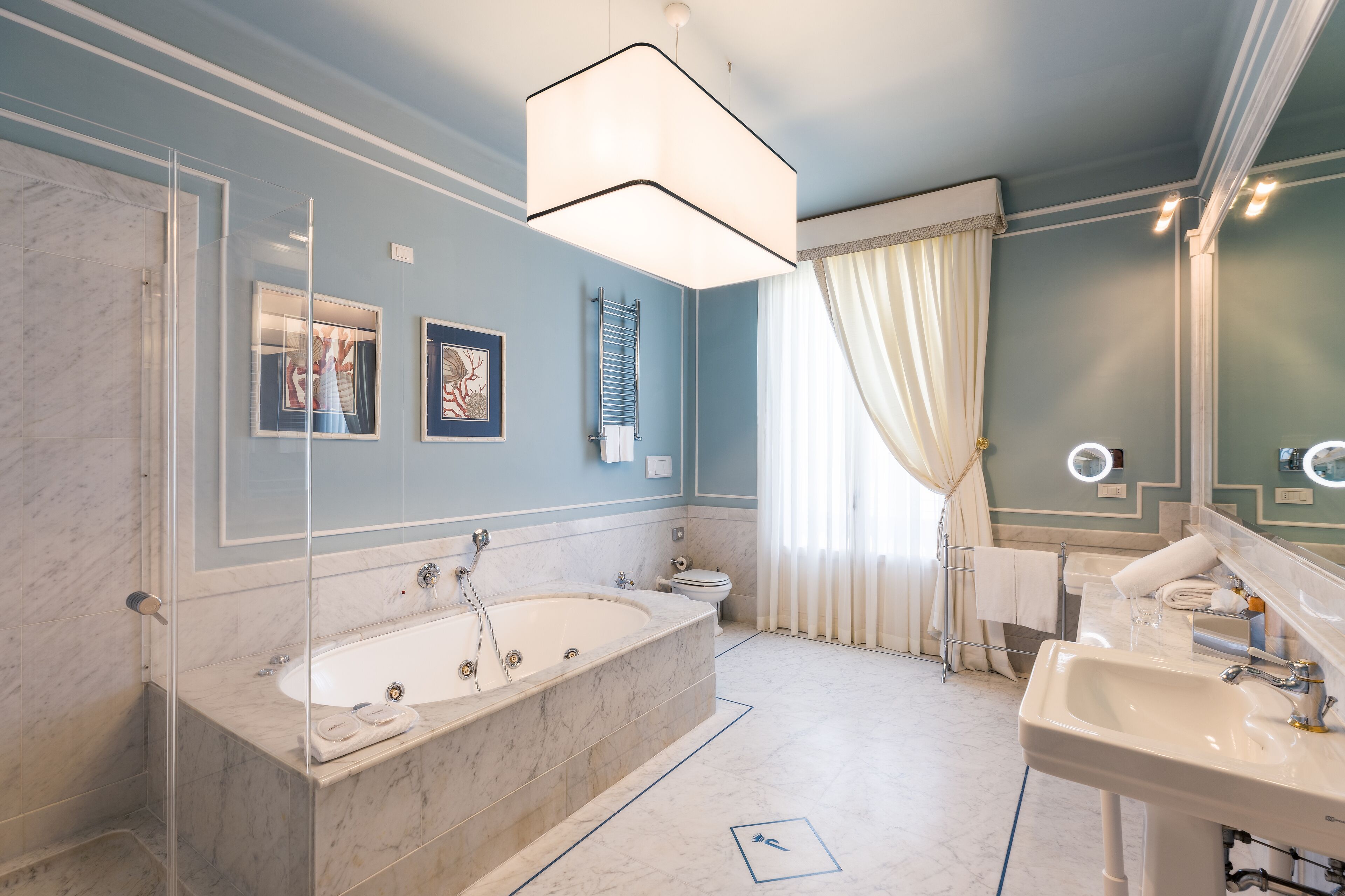 A modern bathroom with a freestanding bathtub, a large mirror, and a vanity with a sink.