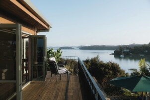 A balcony with a view of a lake and distant hills.