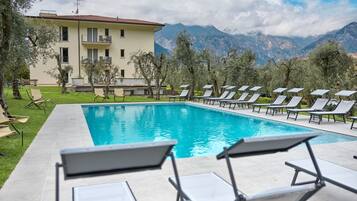 Una piscina al aire libre de temporada, sillones reclinables de piscina