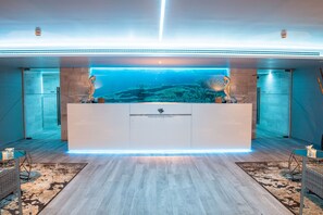 A reception area with a large aquarium, a reception desk, and a modern interior design.
