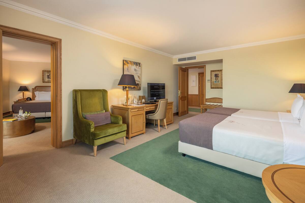 Una habitación de hotel con cama, escritorio, silla y televisión.