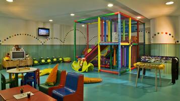 Kids can play safely on the colorful play structure with slides and climbing elements, surrounded by a safety net.