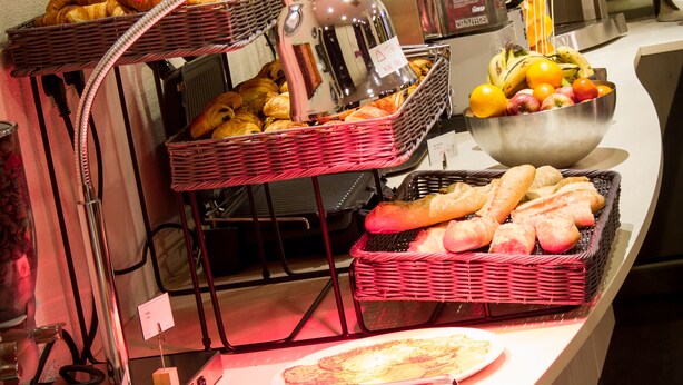 Un bufé con diversos alimentos, incluyendo pan, bollería y frutas.