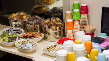 Une table de buffet avec divers plats et des gobelets jetables.