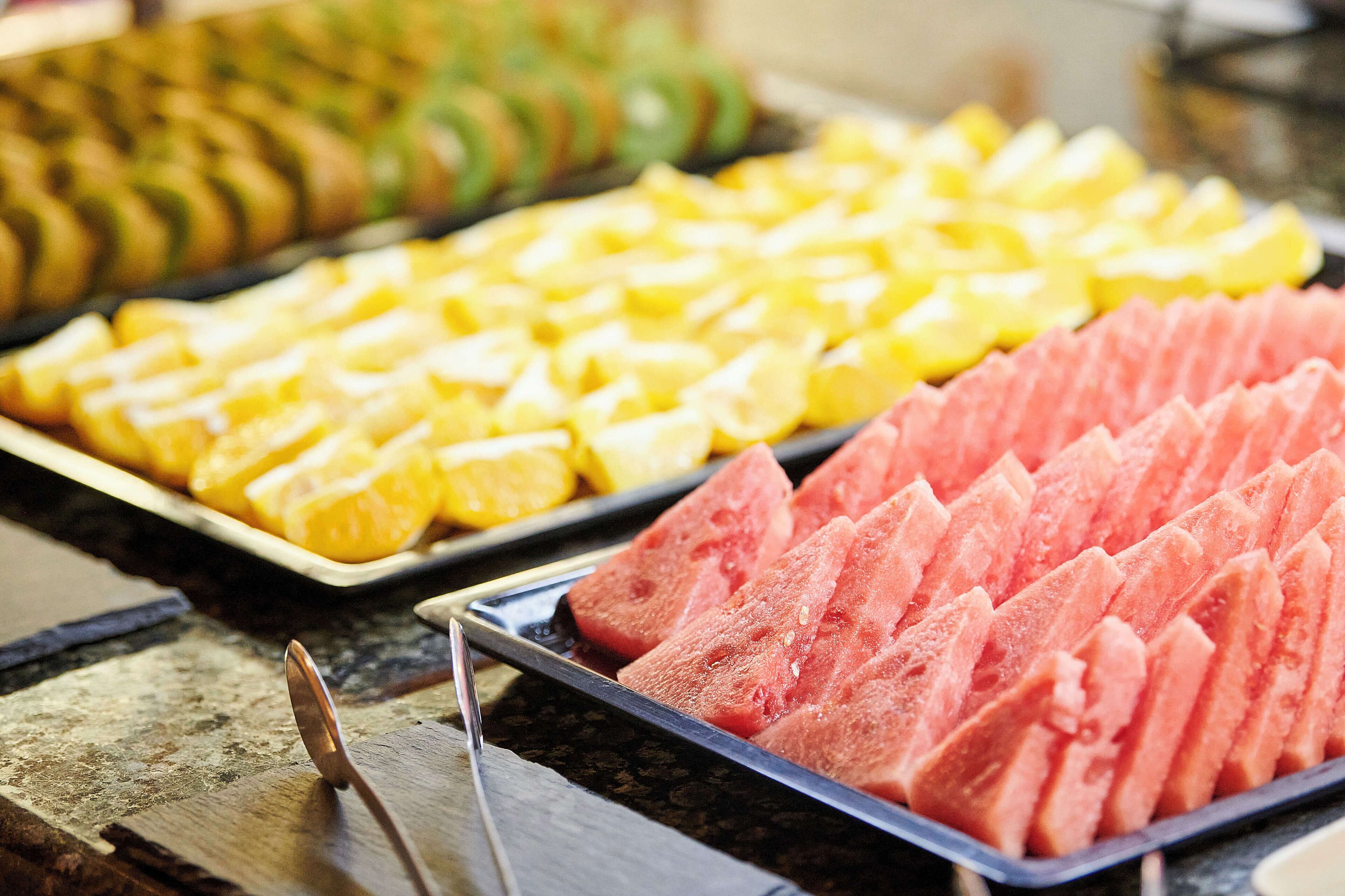 A tray of sliced fruits including watermelon and pineapple.