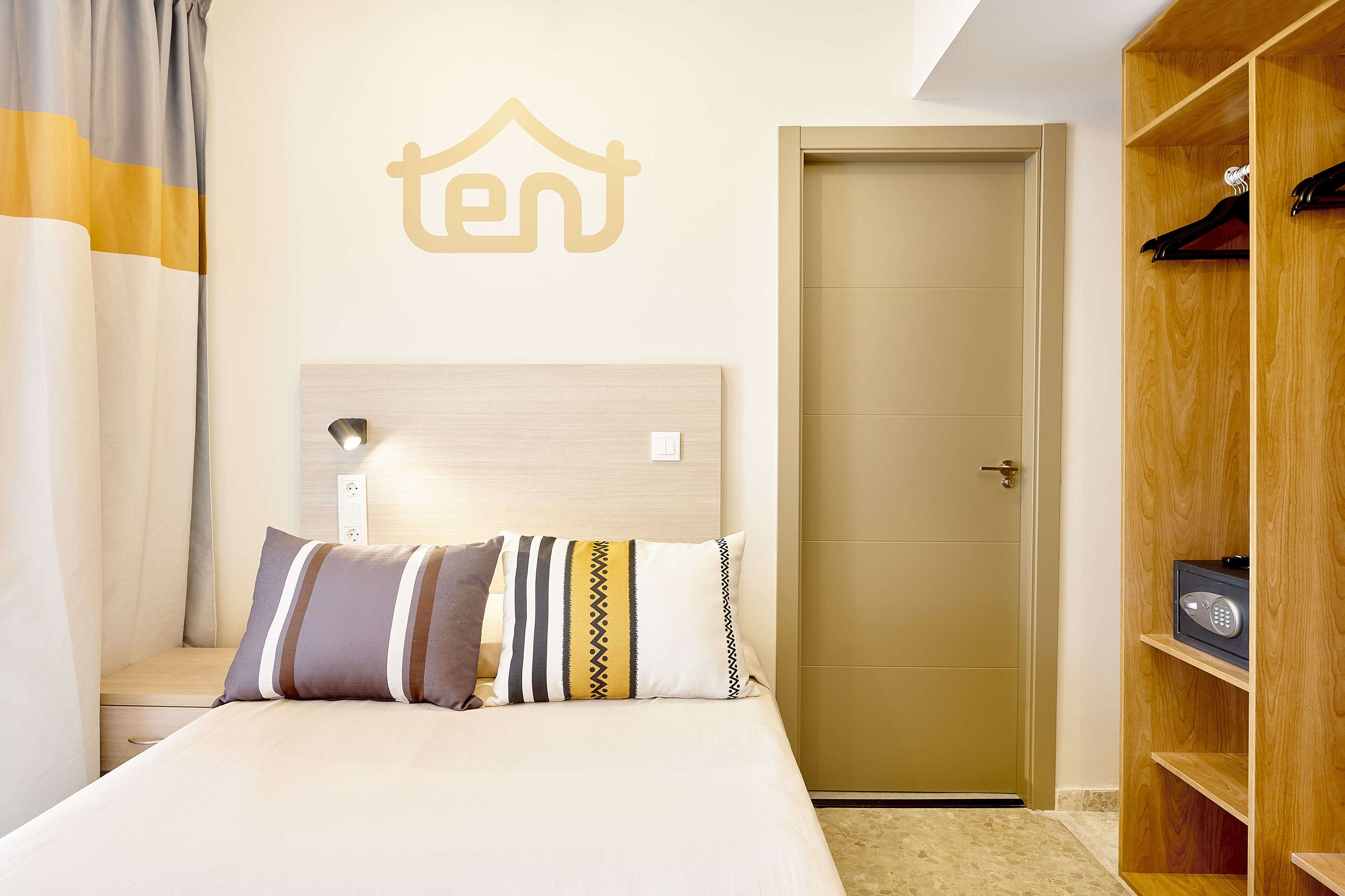 Een hotelkamer met een bed, een kledingkast en een deur.