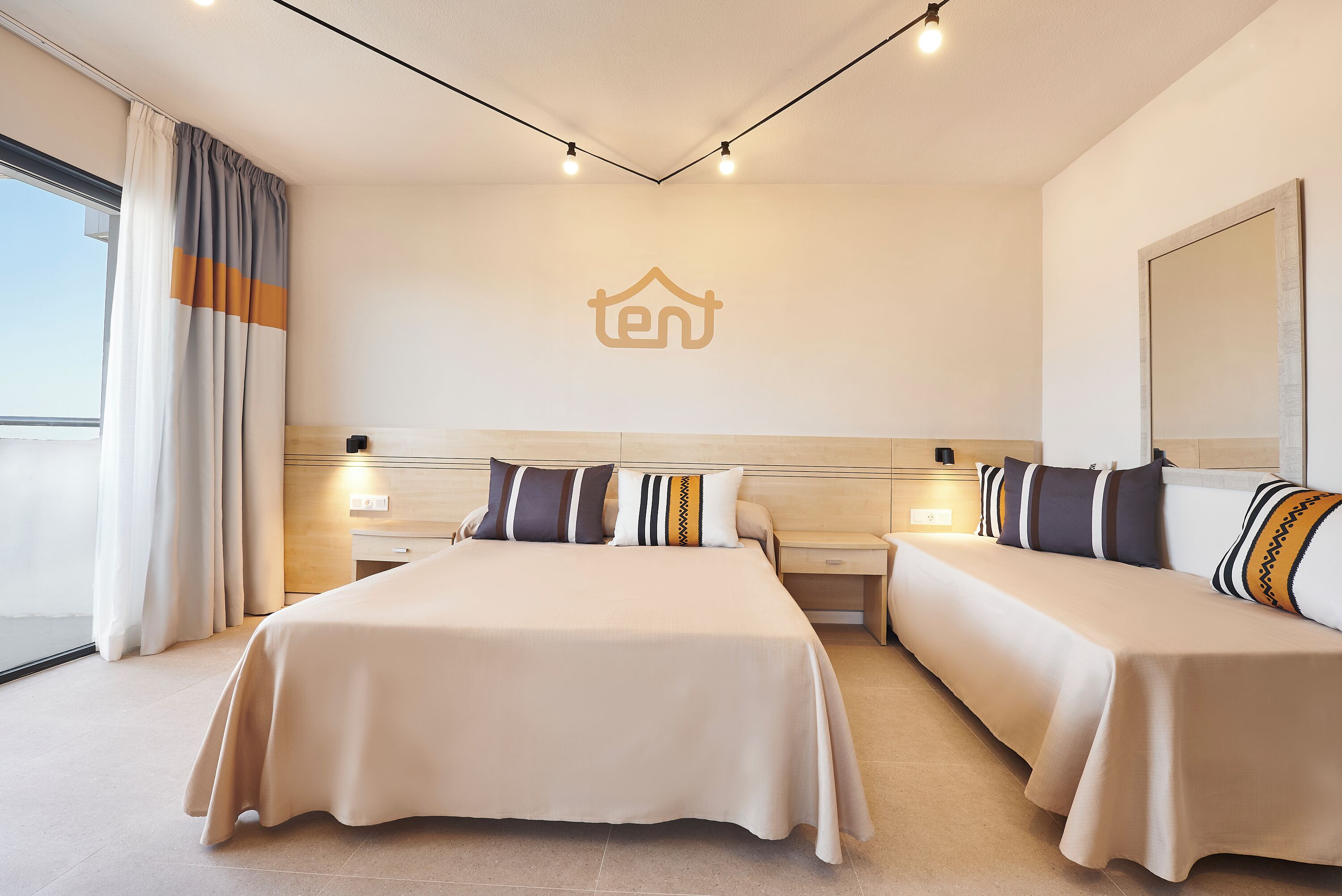 Una camera d'albergo con un letto grande, due comodini e una testiera.