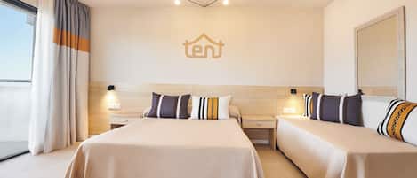 Une chambre d’hôtel avec un grand lit, deux tables de chevet et une tête de lit.