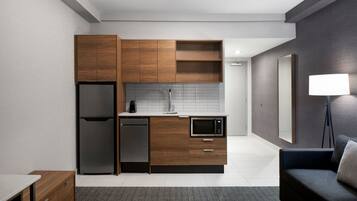 A modern kitchen with wooden cabinets, a built-in microwave, a refrigerator, and a dishwasher.