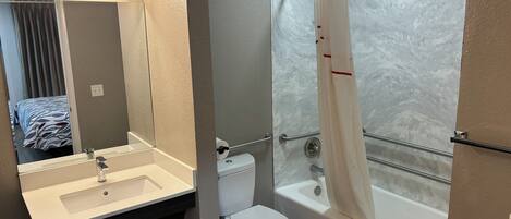 Un baño con lavamanos, inodoro y bañera.