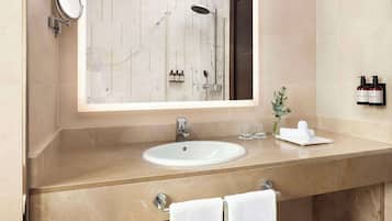 A modern bathroom with a large mirror, a sink, and a shower.