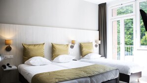 A hotel room with two beds, a large window with curtains, and bedside lamps. - Apple Inn Hotel (Amsterdam)