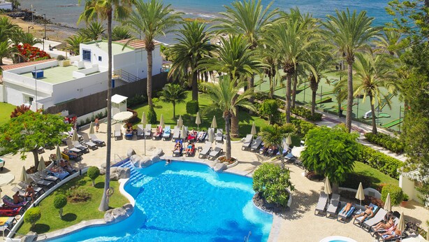 A resort pool area with a view of the ocean and a mountain in the background. - H10 Big Sur Boutique Hotel (Arona)