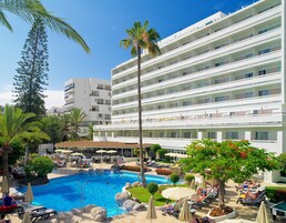 Un hotel con zona de piscina, varios balcones y mobiliario de exterior.