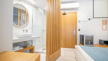 Un baño moderno con tocador de madera, un espejo grande y cabina de ducha de vidrio.