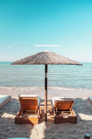 In Strandnähe, Liegestühle, Sonnenschirme, Strandtücher