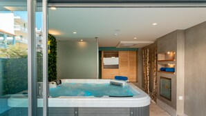 Un moderno espacio de spa con un jacuzzi, armarios de madera y una puerta de cristal que da a un área exterior.
